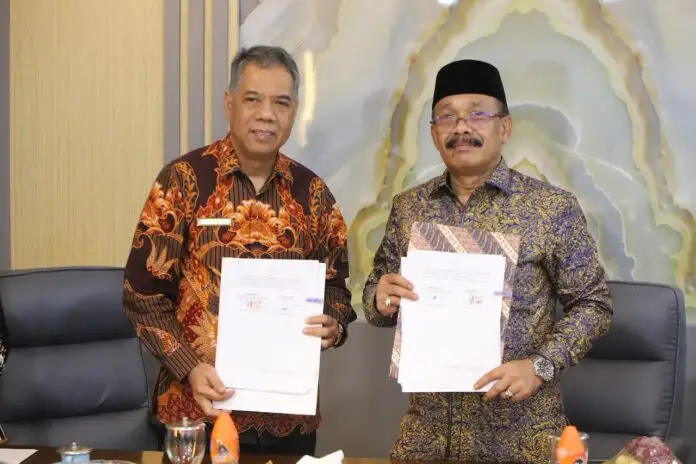 Bupati Pidie H. Sarjani Abdullah (kanan) bersama Kepala Kanwil DJKN Aceh Rachmat Kurniawan (kiri) menunjukkan dokumen Perjanjian Kerja Sama terkait pengelolaan Barang Milik Daerah (BMD) usai penandatanganan di Pendopo Bupati Pidie, Kamis (13/8/2026).