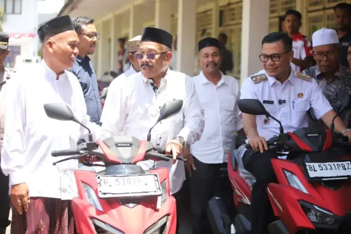 Bupati Pidie, H. Sarjani Abdullah, M.H. (tengah), didampingi Wakil Bupati Pidie, Alzaizi (kanan berseragam), saat berdialog dan menyerahkan secara simbolis bantuan sepeda motor operasional Honda Vario kepada perwakilan Imum Mukim di Halaman Tengah Kantor Bupati Pidie, Rabu (19/08/2026).